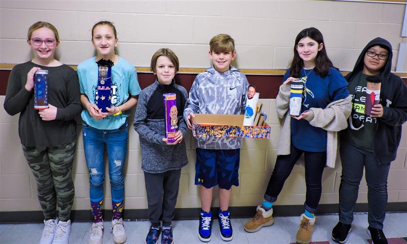 Students hold up Characters in a Can